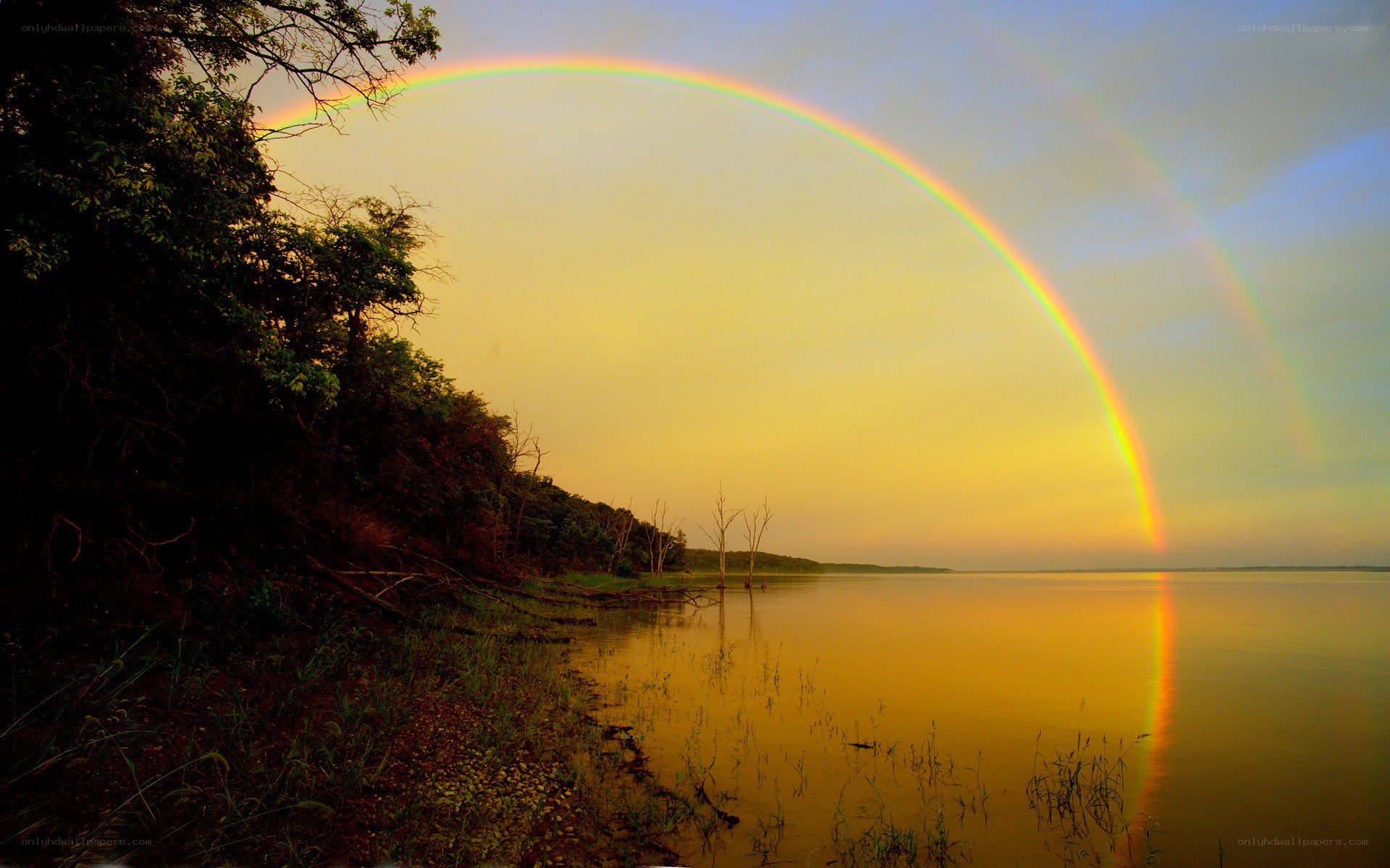 Rainbow over a lake at sunset