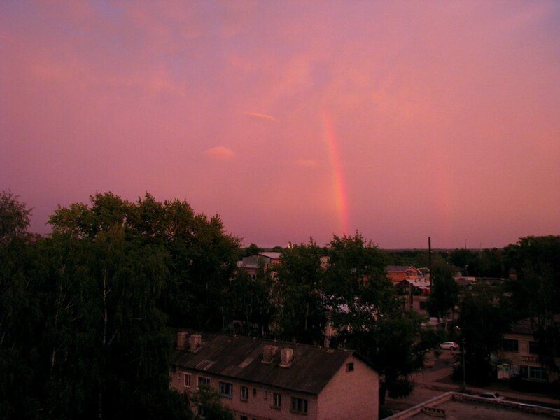 Rainbow over a town at dusk