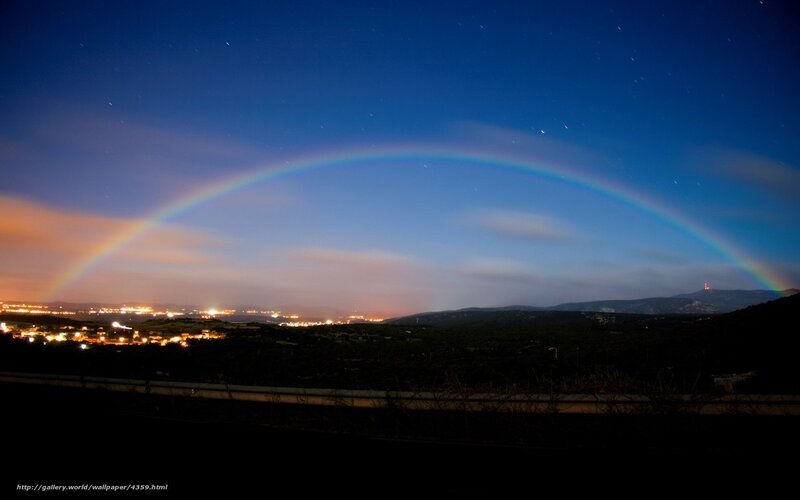 Rainbow over a town at night