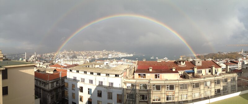 Rainbow over City — Gray, Dramatic