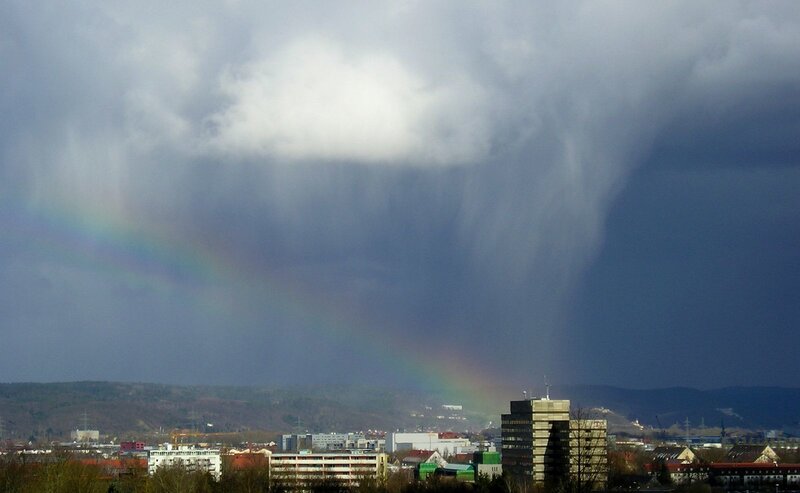 Rainbow over city with storm