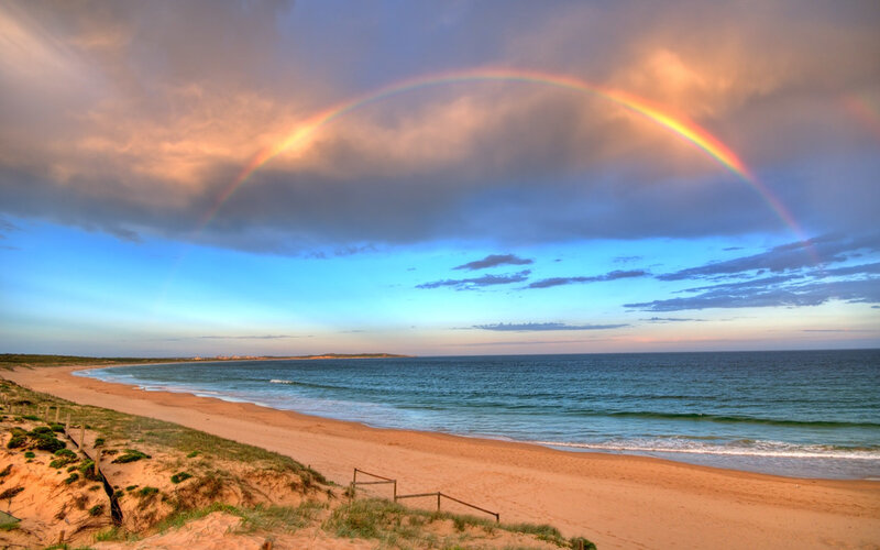 Rainbow over coastal beach
