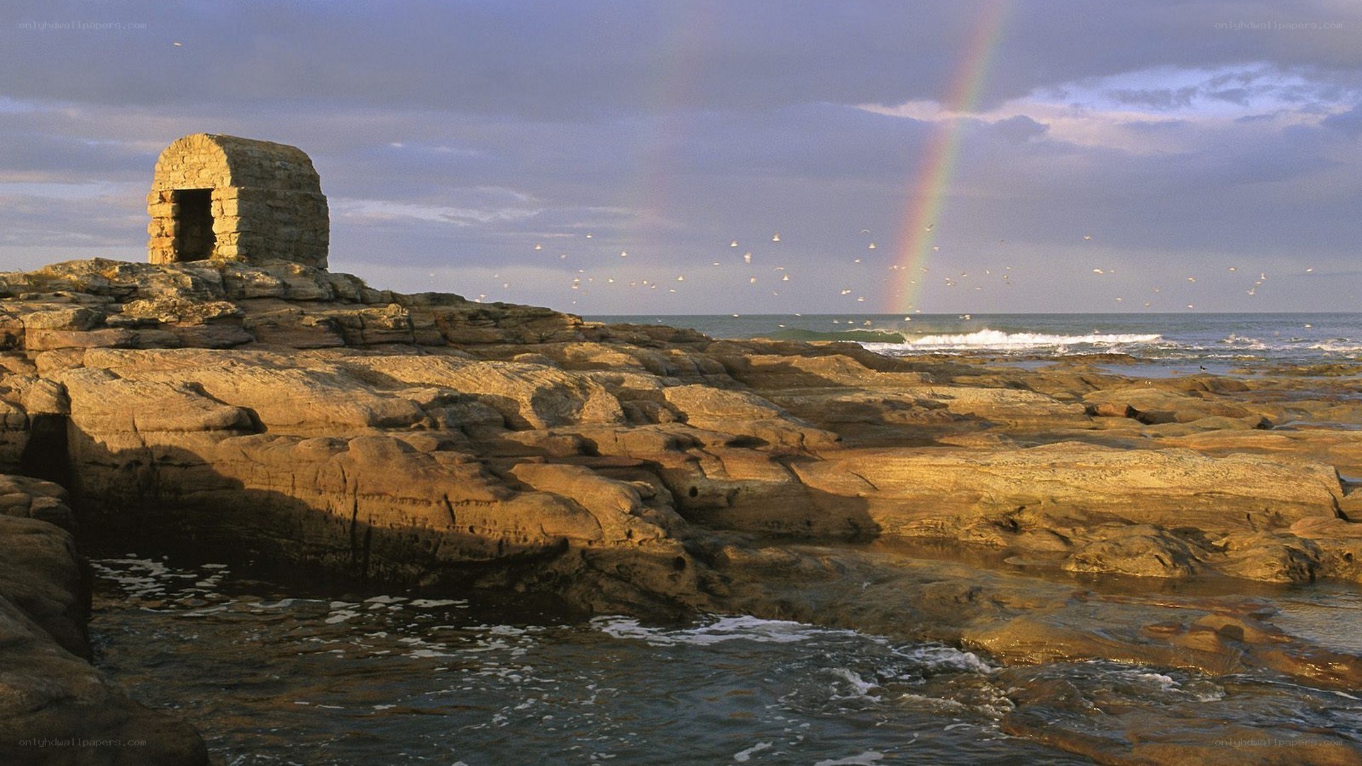 Rainbow over coastal ruin