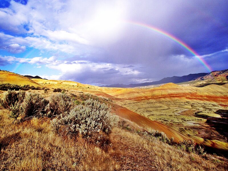 Rainbow over colorful hills