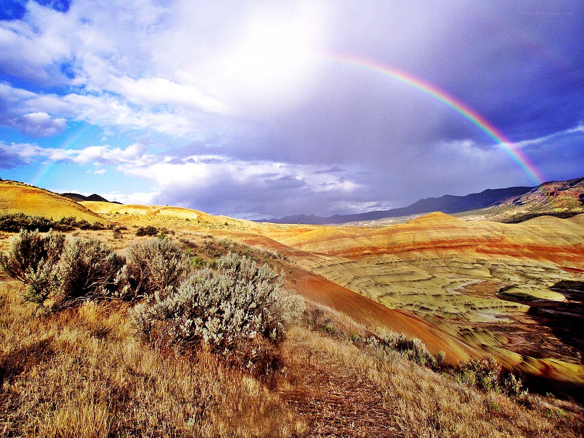 Rainbow over colorful hills
