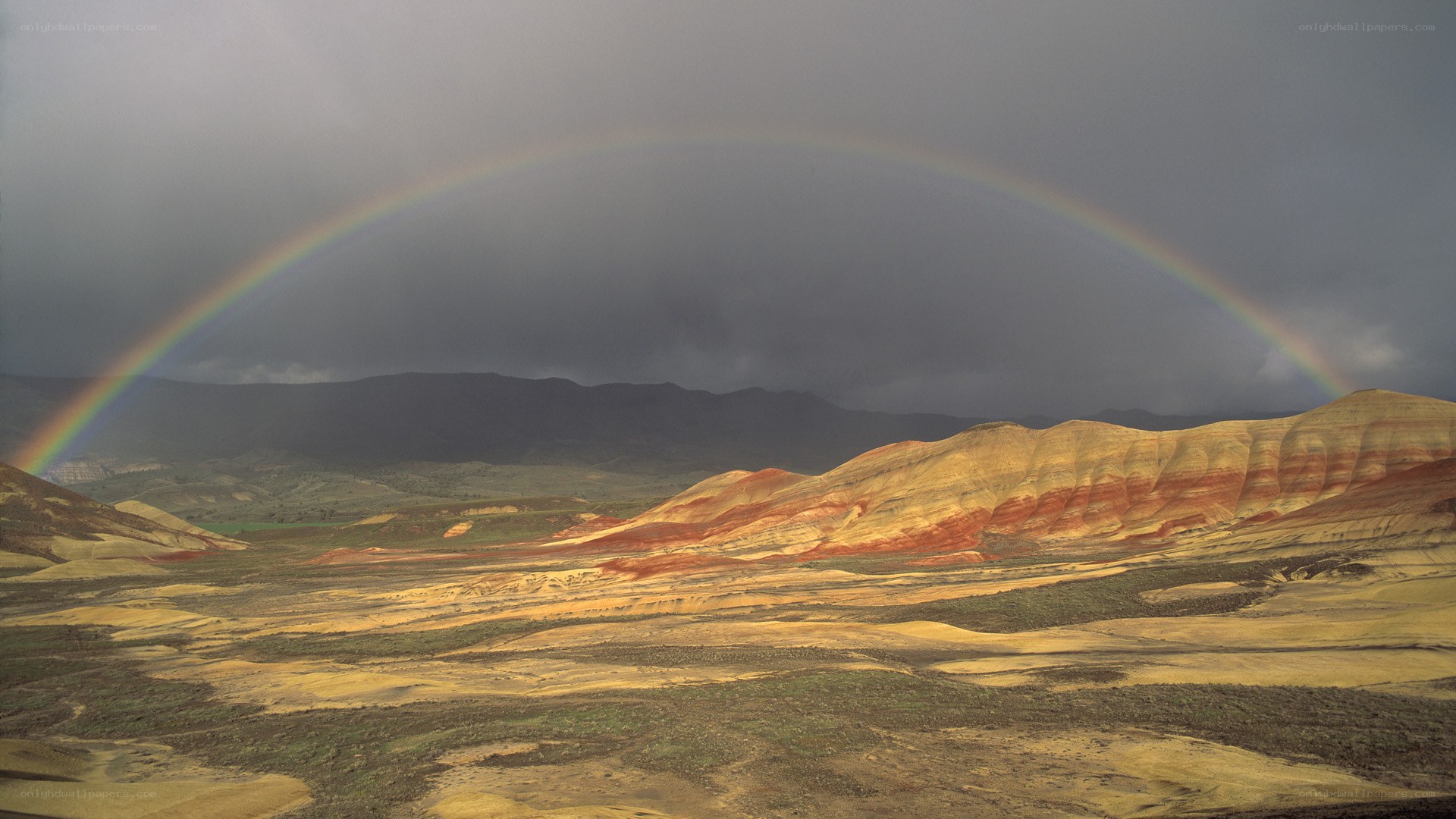 Rainbow over colorful hills