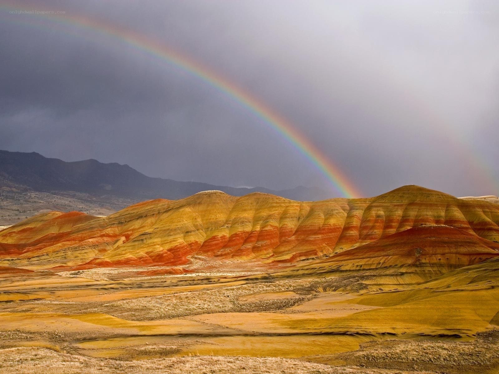 Rainbow over colorful hills