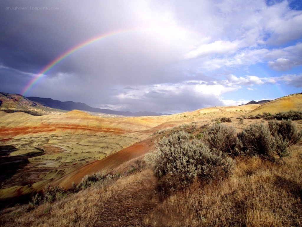 Rainbow over colorful hills