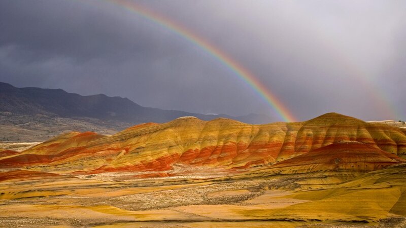 Rainbow over colorful hills