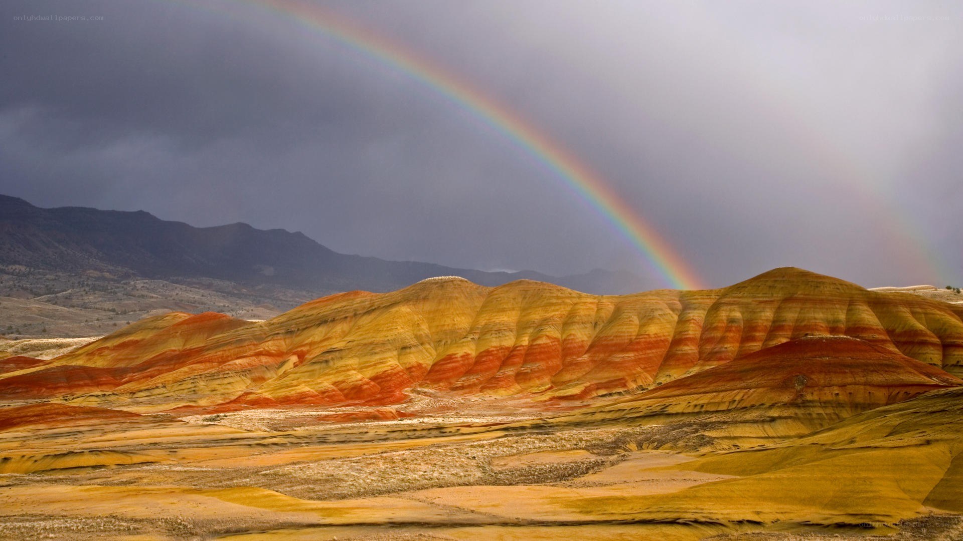 Rainbow over colorful hills