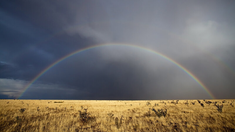 Rainbow over desert landscape
