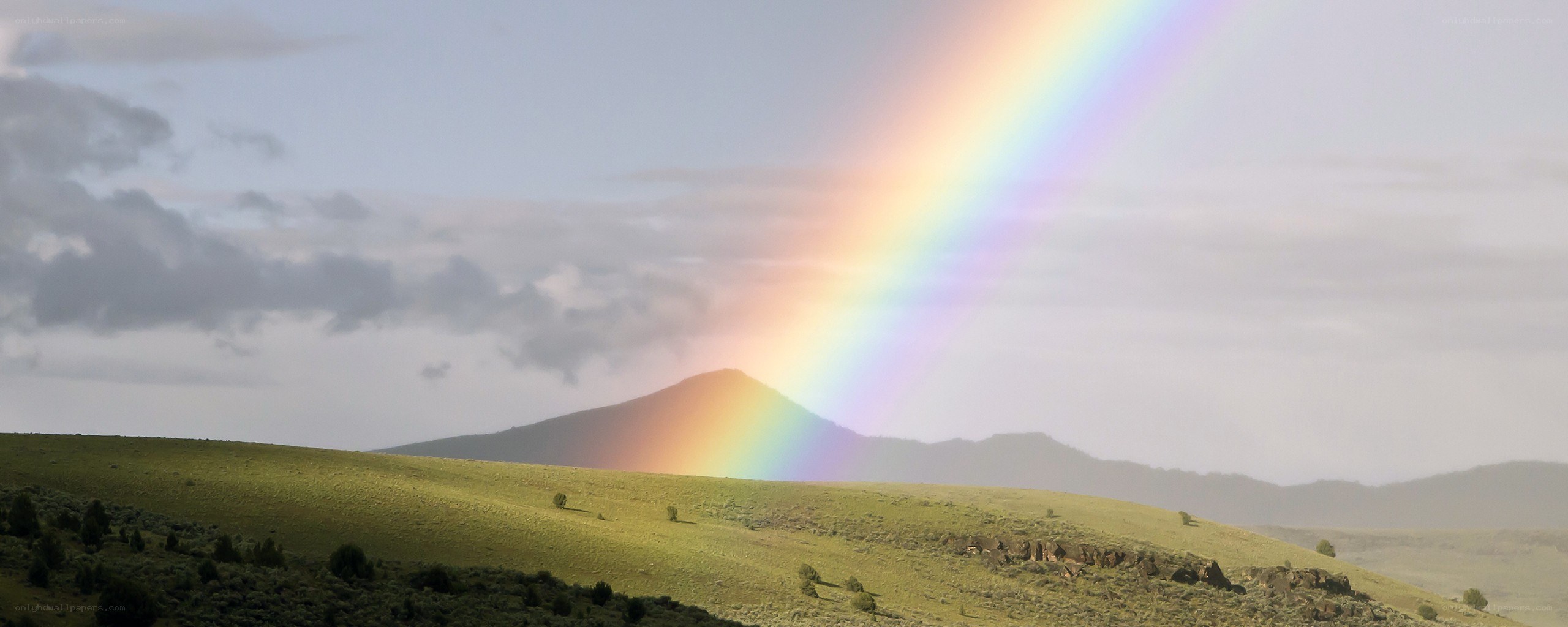 Rainbow over green hills