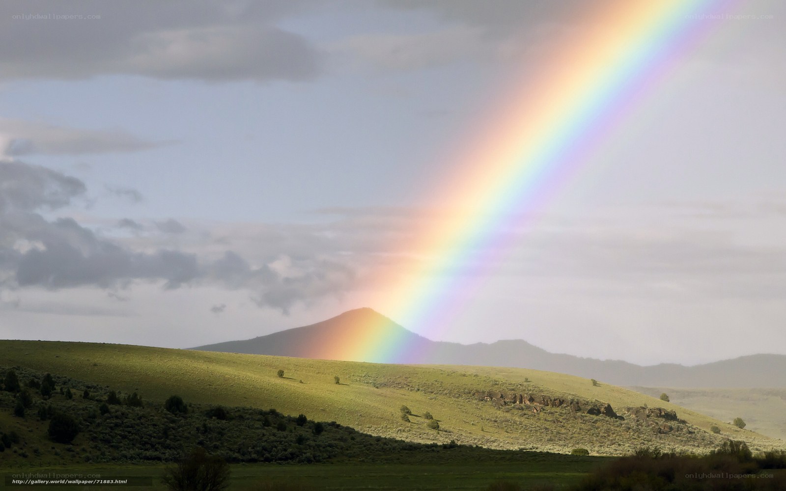 Rainbow over green hills