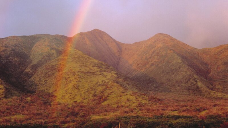Rainbow over green mountains