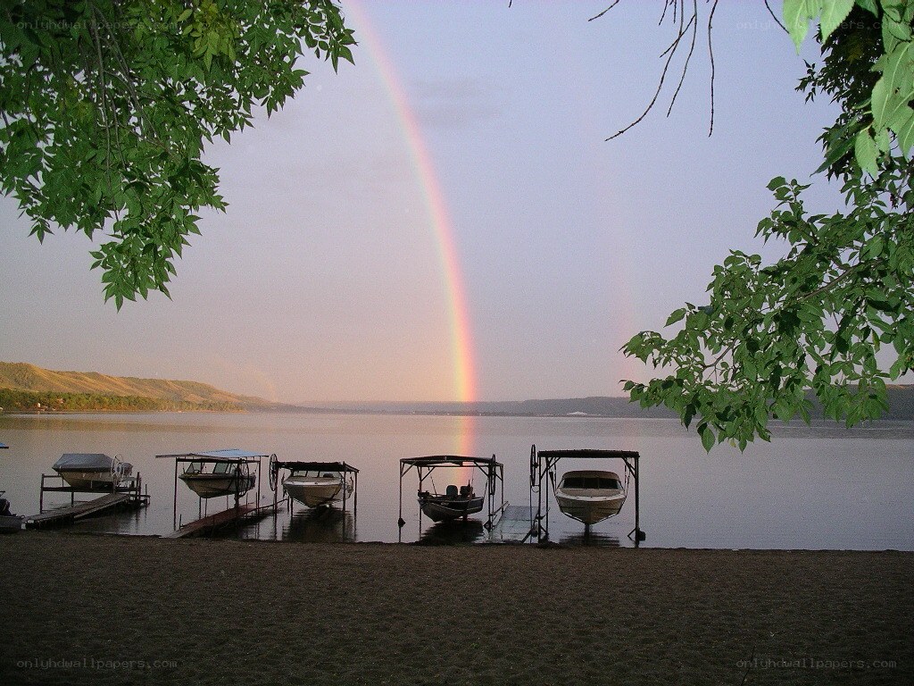 Rainbow over lake with boats