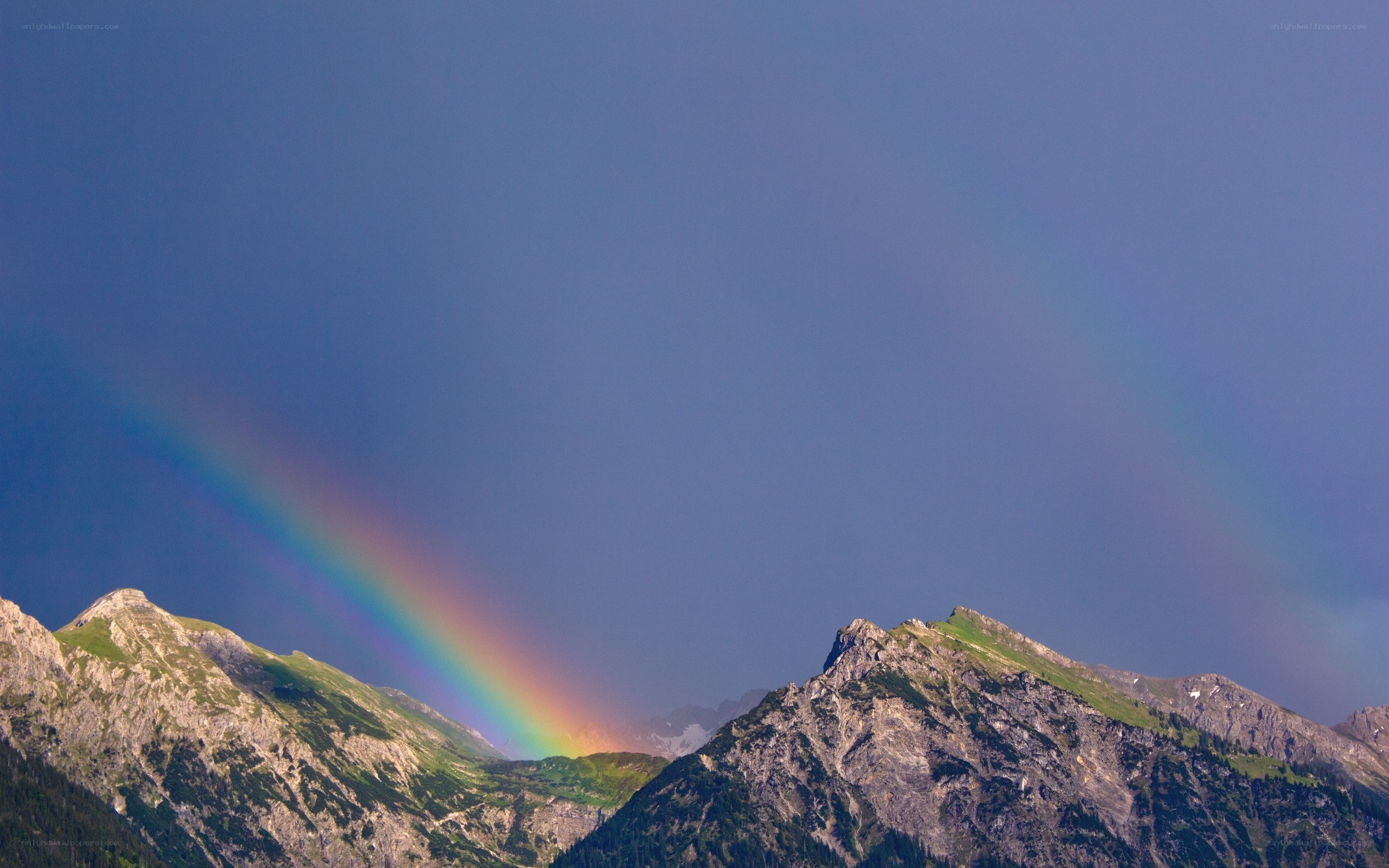 Rainbow over mountain peaks