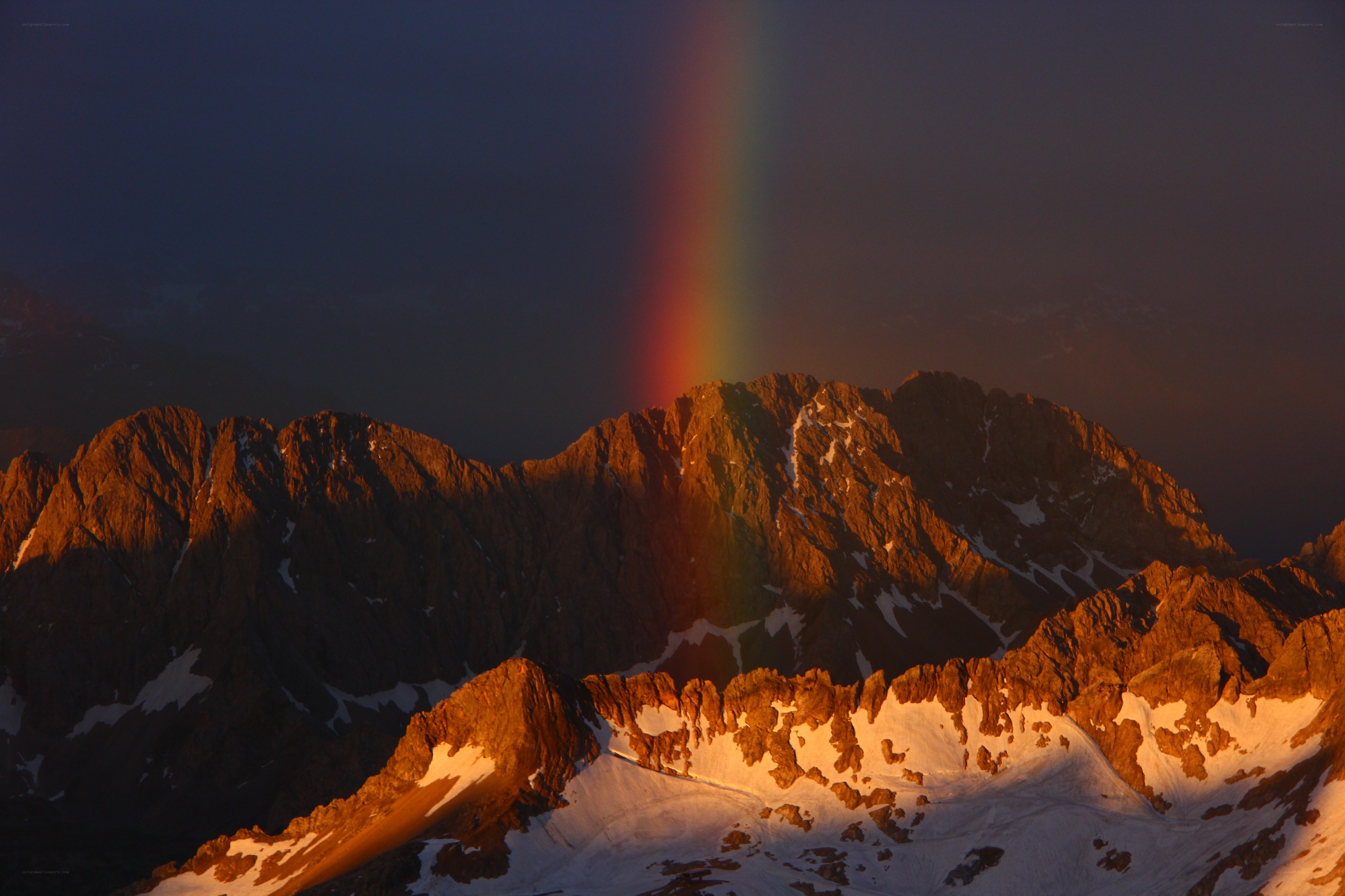 Rainbow over mountain peaks