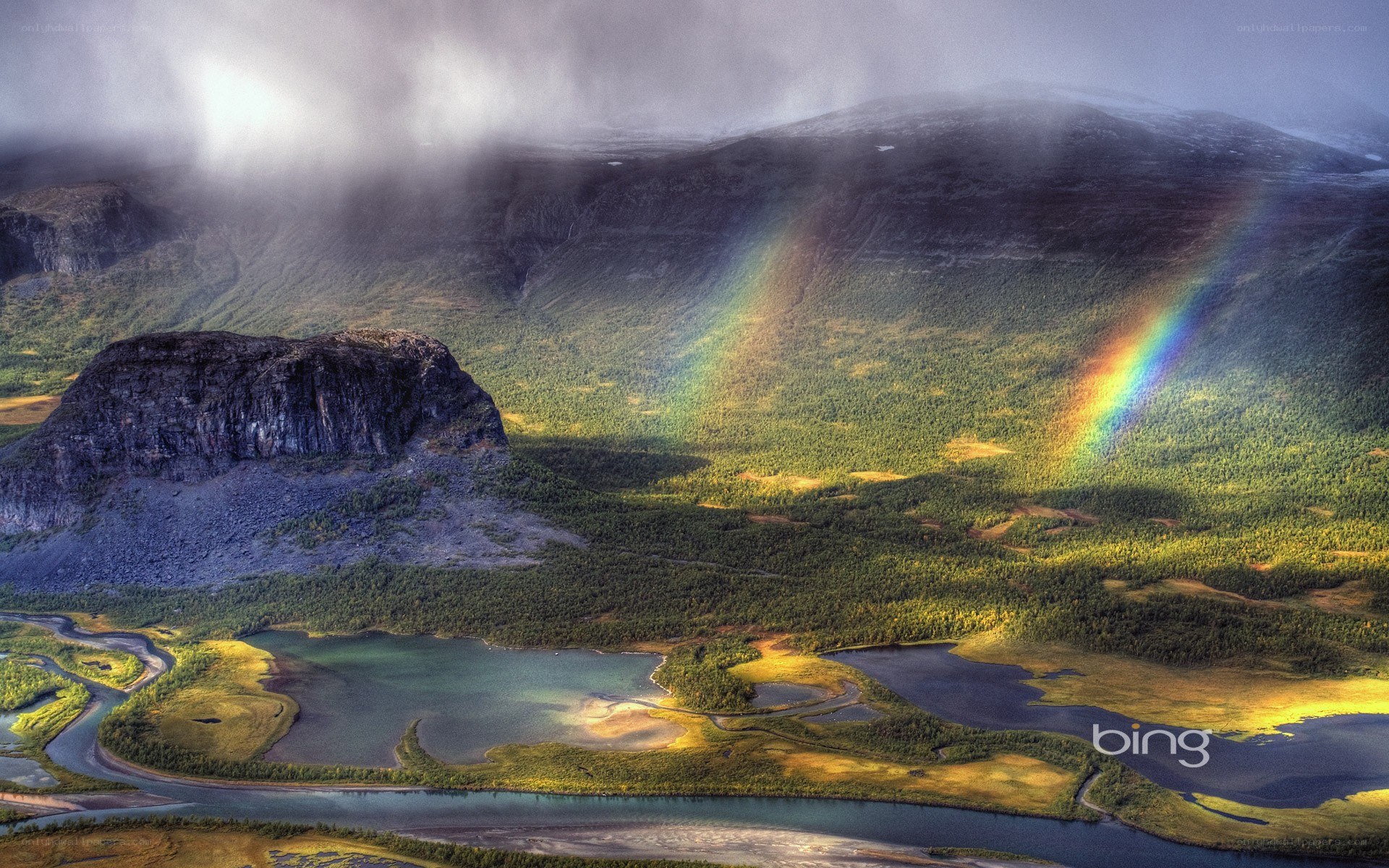 rainbow over mountain valley