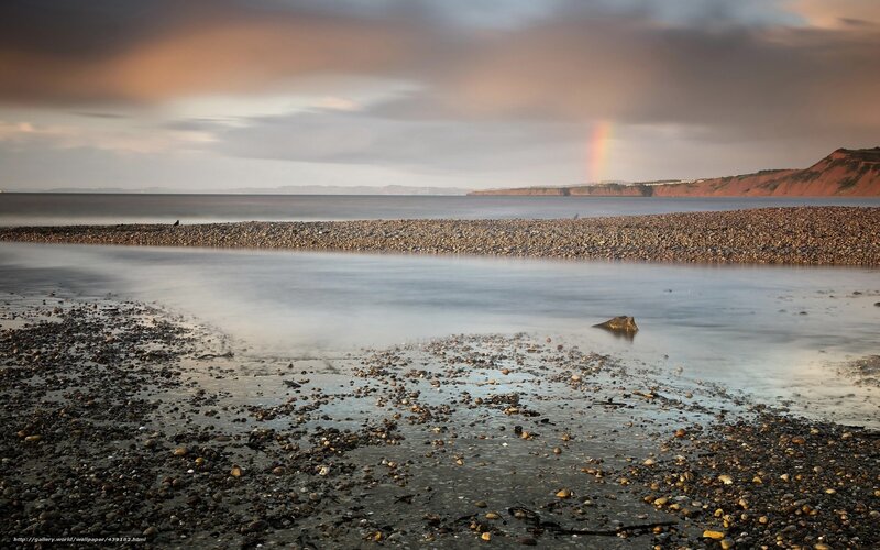Rainbow over pebble beach