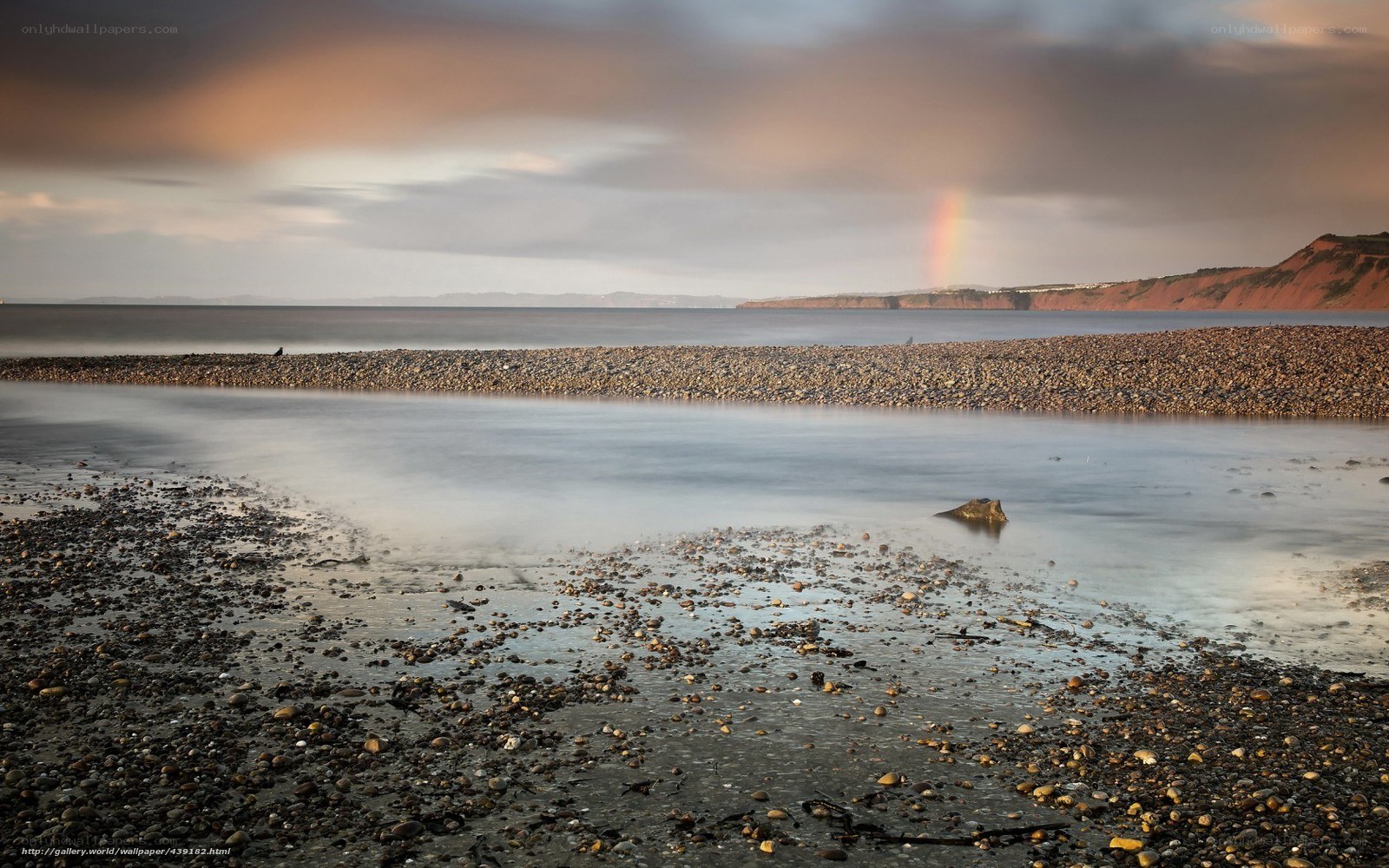Rainbow over pebble beach