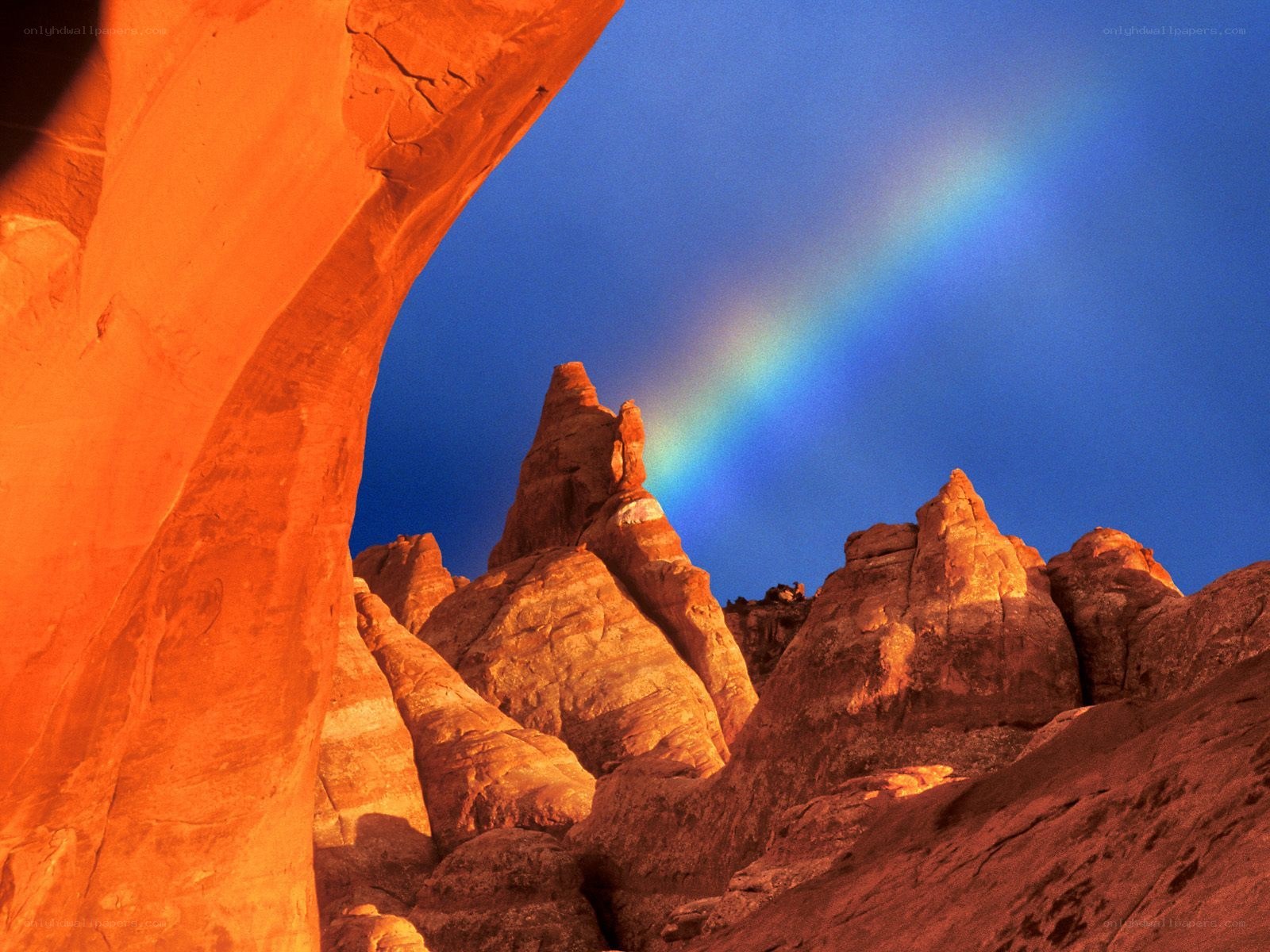 Rainbow over red rock arch