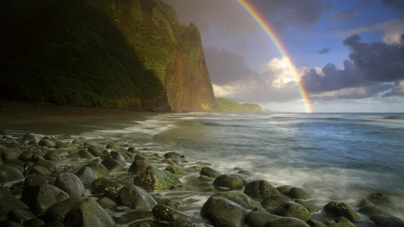 Rainbow over rocky beach