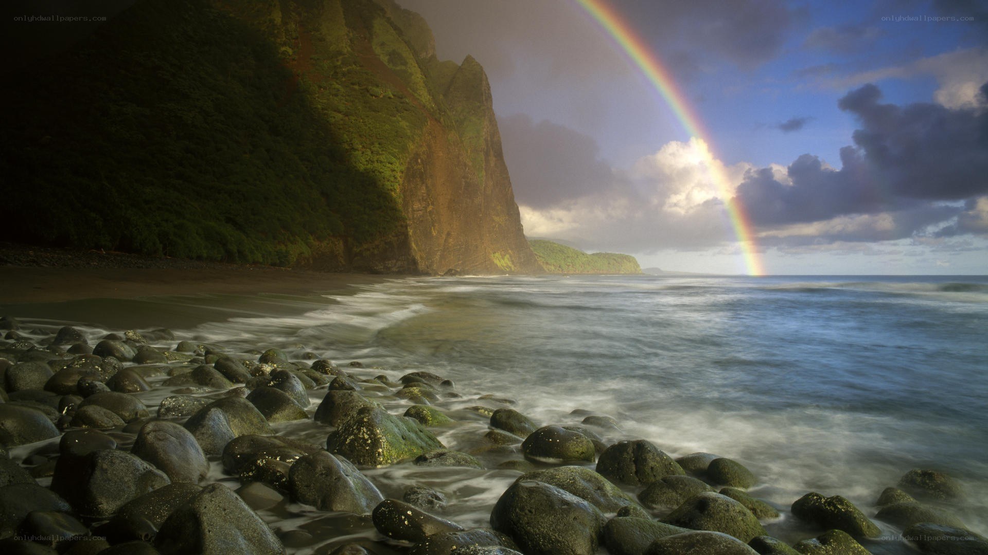 Rainbow over rocky beach