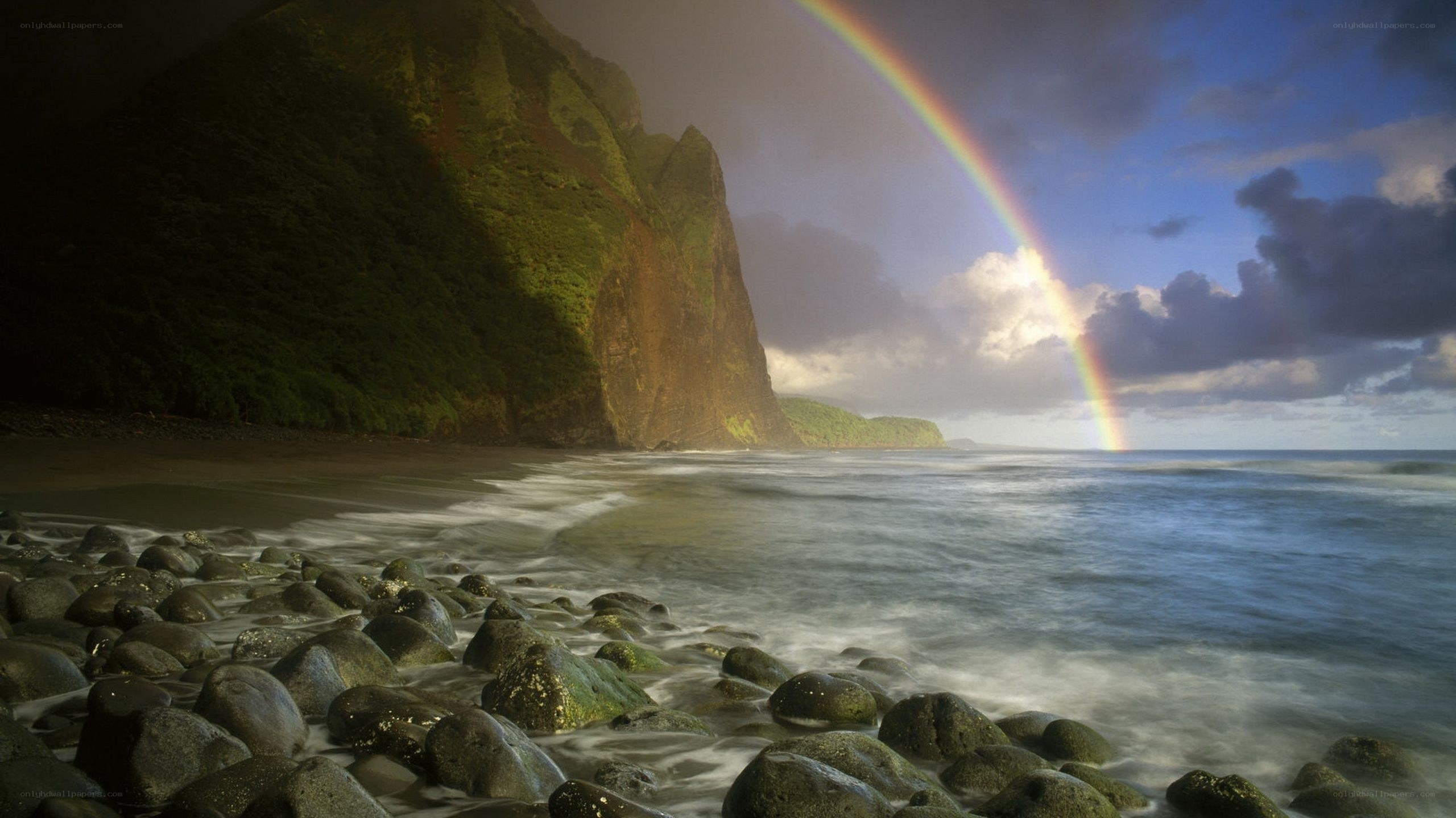 Rainbow over rocky beach