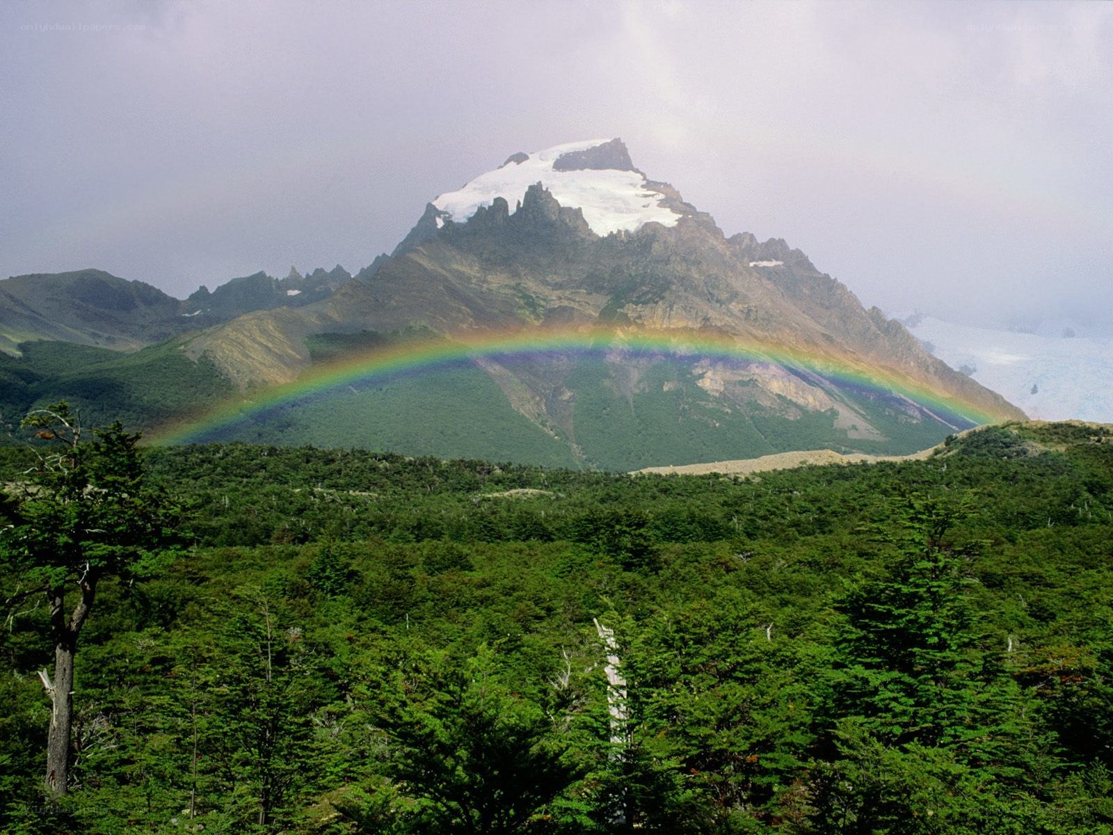 Rainbow over snow-capped mountain