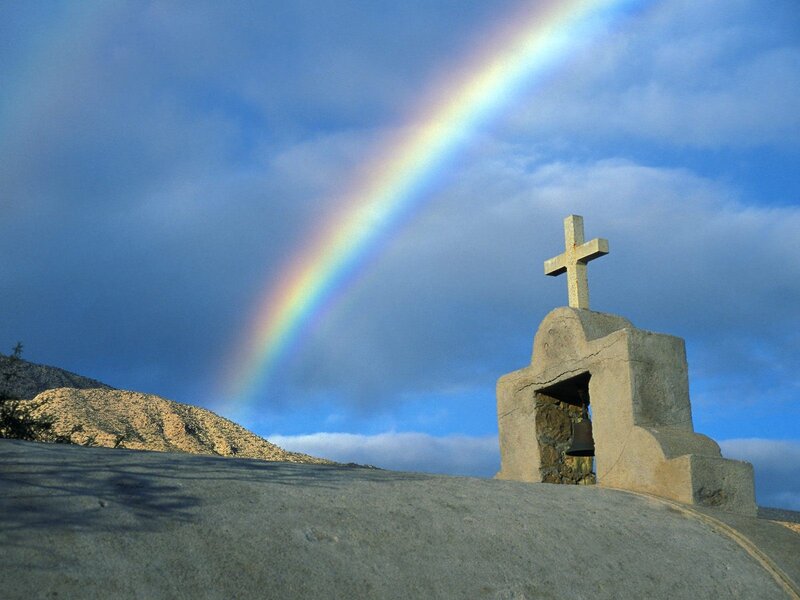 Rainbow over stone cross