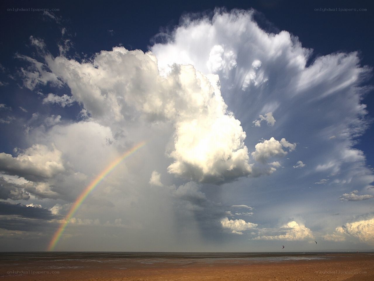Rainbow over stormy beach