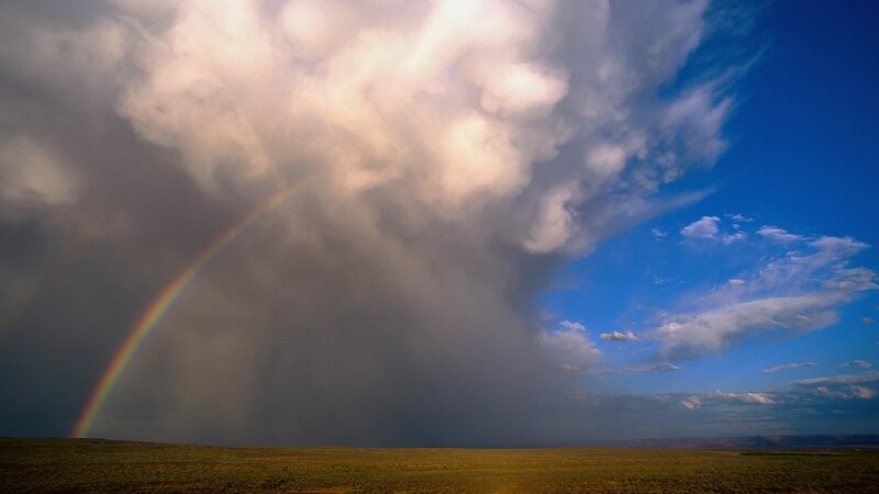 Rainbow over stormy plains