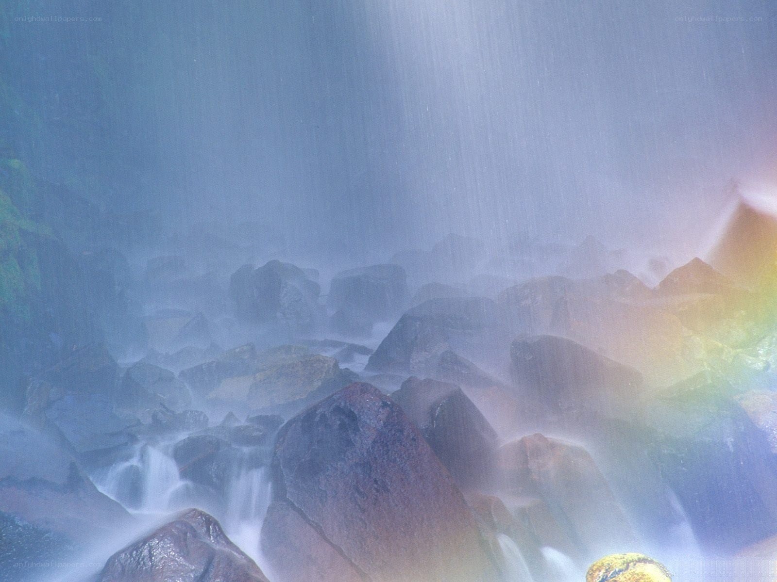 Rainbow over waterfall rocks