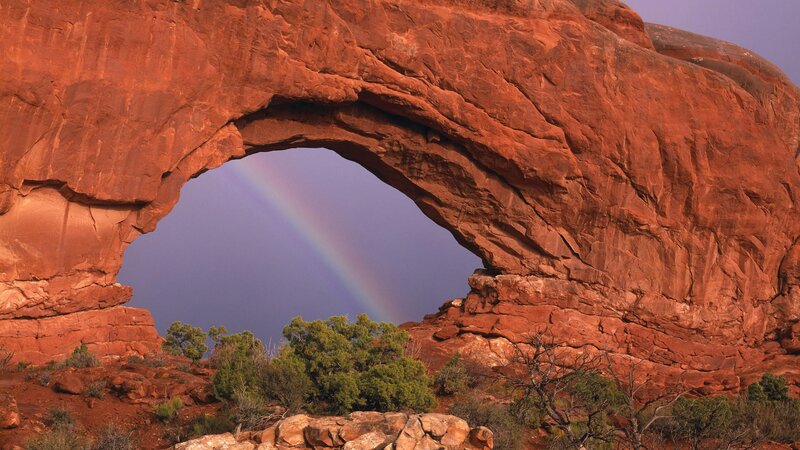 Rainbow through red rock arch