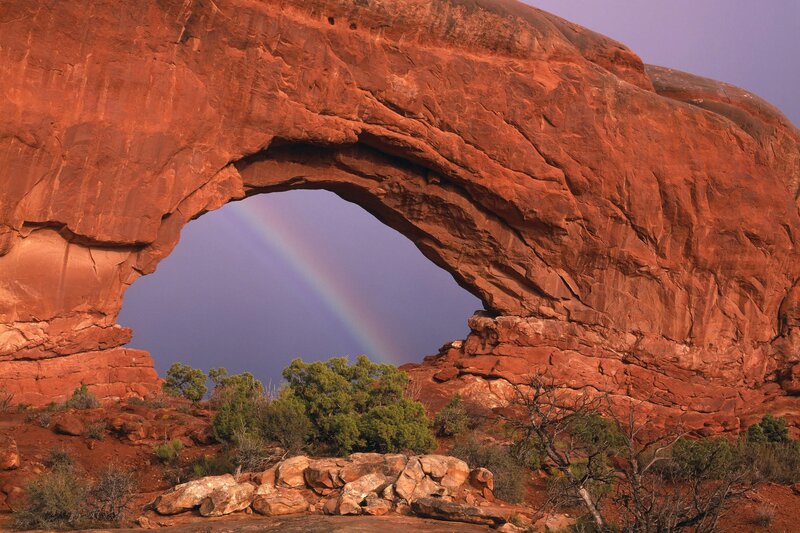 Rainbow through red rock arch