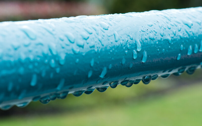 Raindrops on a blue pipe