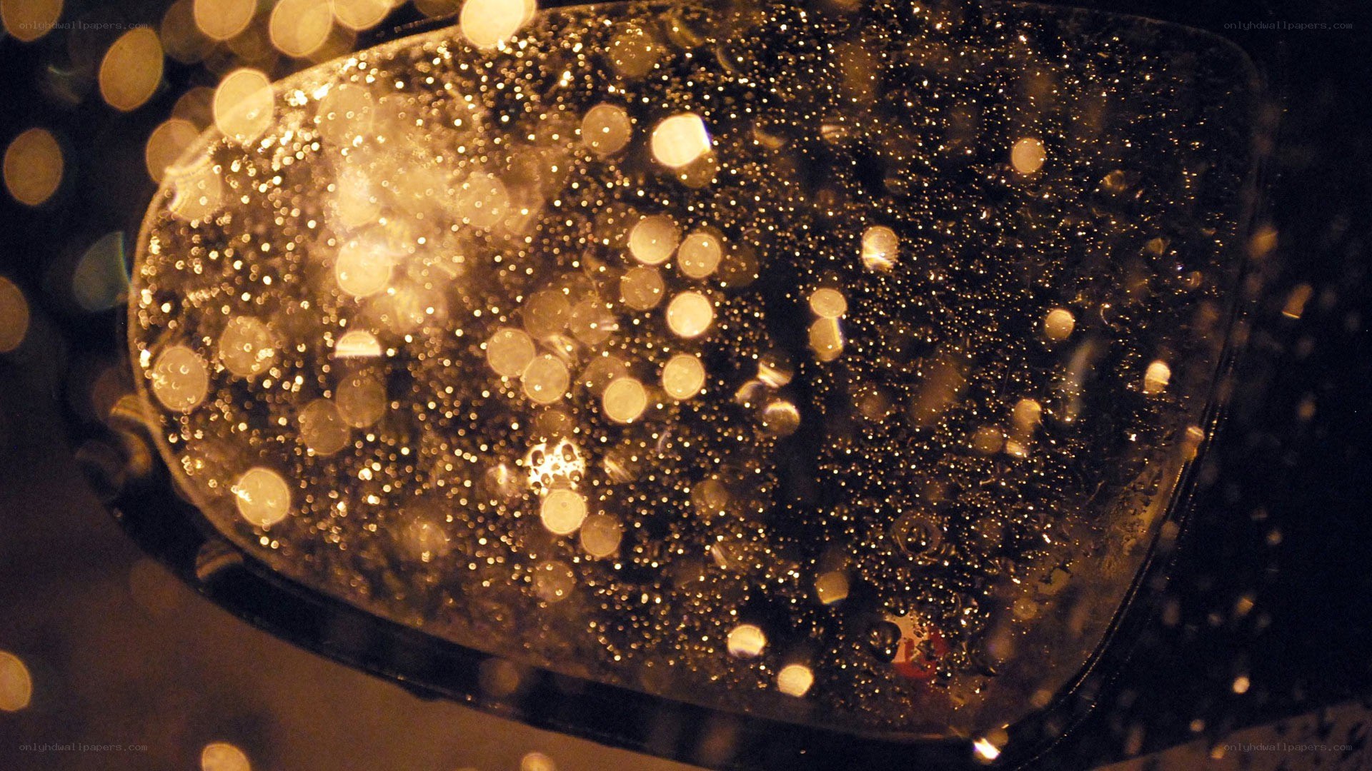 raindrops on a car mirror at night