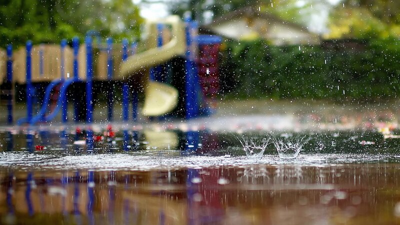 Raindrops on a playground puddle