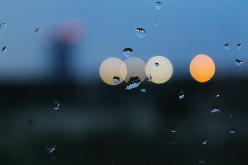 Raindrops on a window at dusk