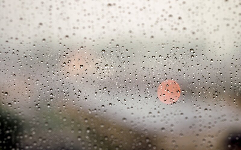 Raindrops on a window with sunset
