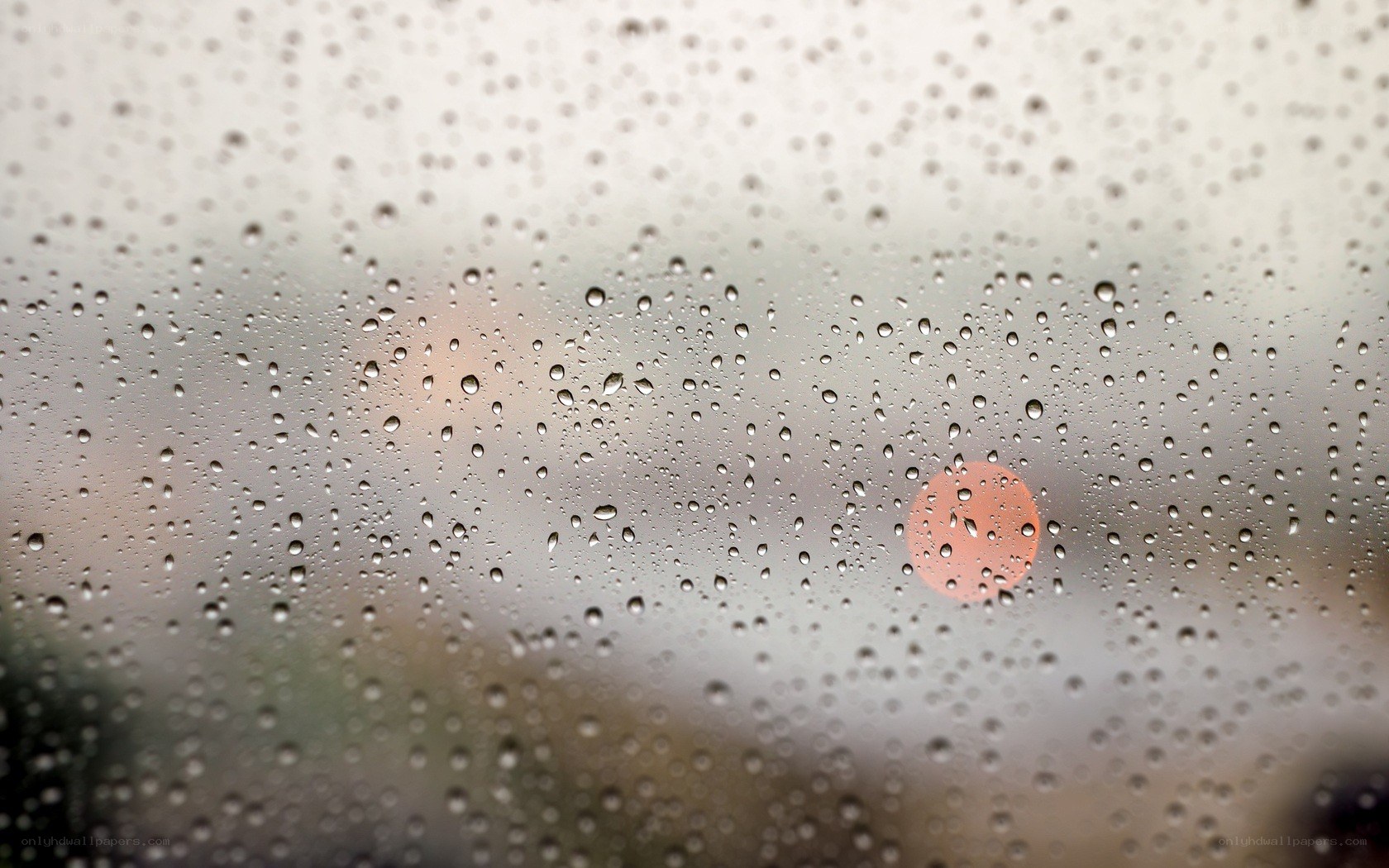 Raindrops on a window with sunset