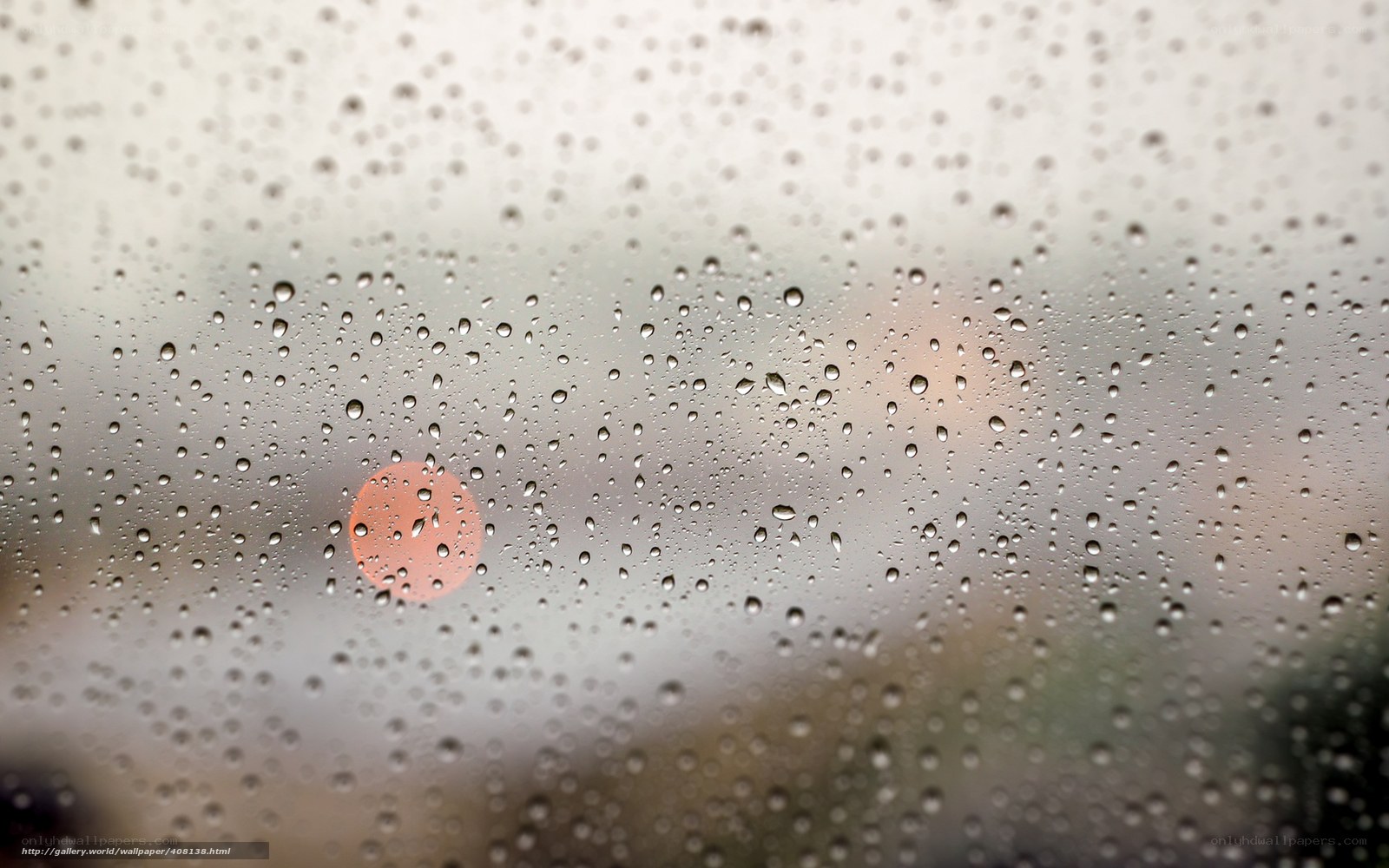 Raindrops on a window with sunset