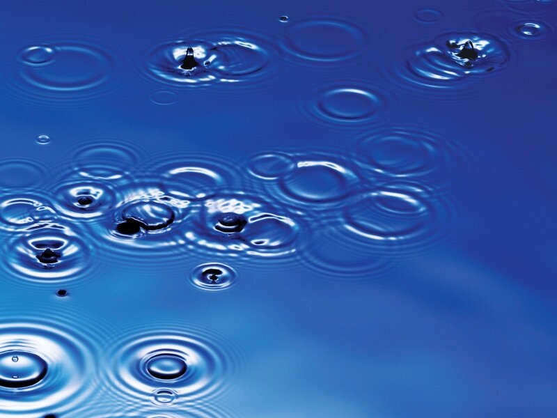 Raindrops on blue water surface