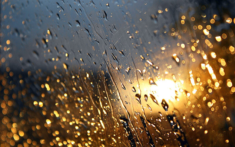 Raindrops on glass with golden lights