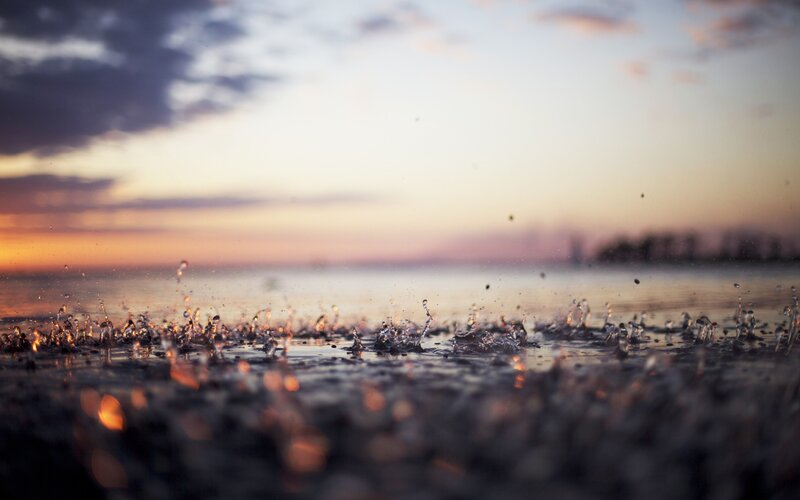 Raindrops on Water Surface — Orange, Serene, Sunset