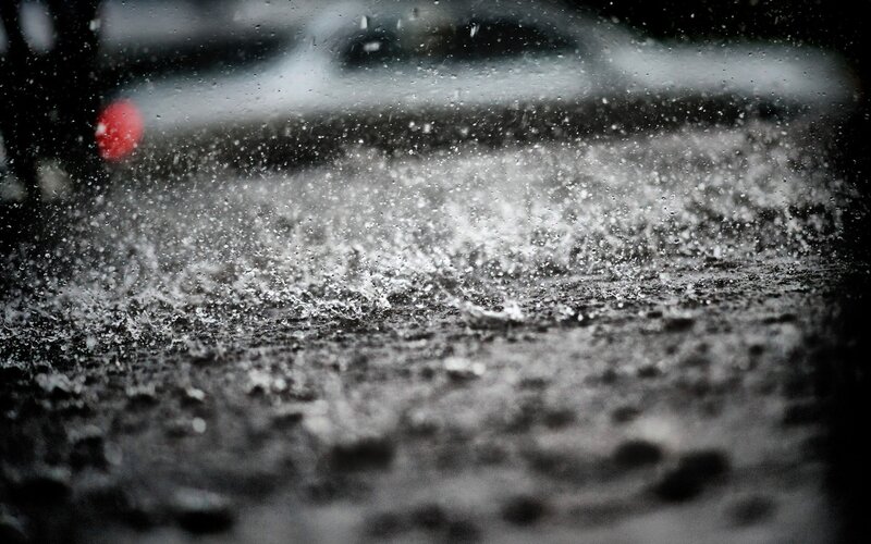 Raindrops splashing on wet pavement