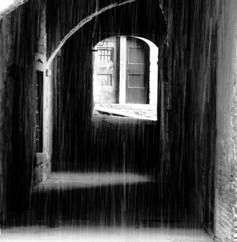 Rainy alley with arched doorway