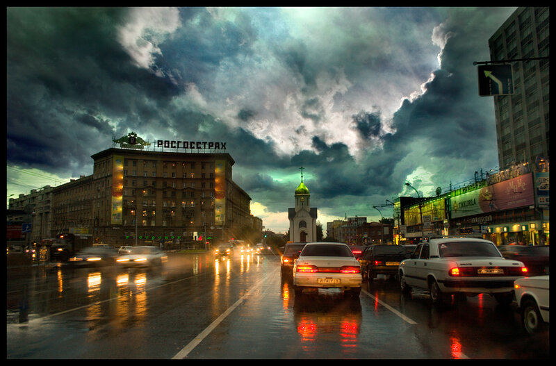 Rainy city street with storm clouds