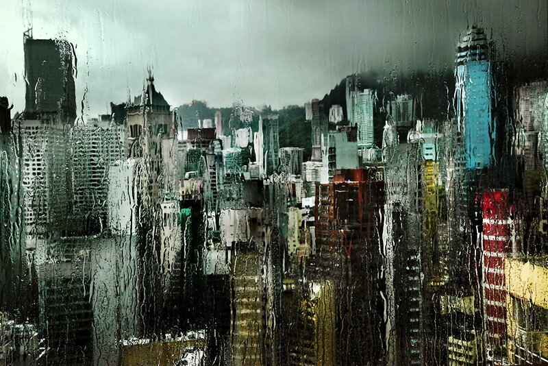 rainy cityscape through wet glass