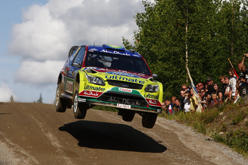 Rally car jumping on dirt road